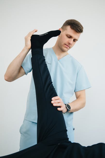 Professional physiotherapist helping a patient with leg exercises in a clinic setting.